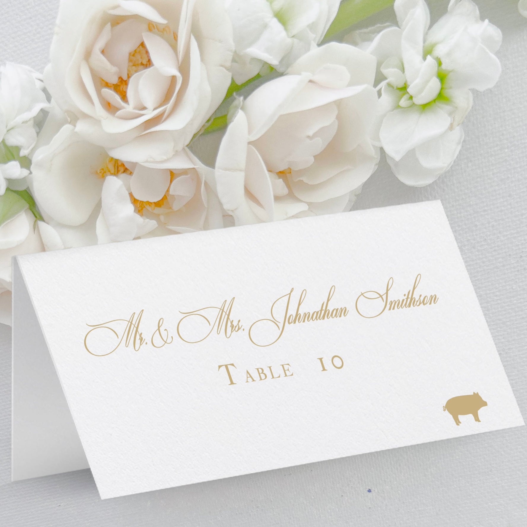 Folded Place cards, tented escort cards for wedding feature guest names in script, table number in text font, and meal choice icon, gold ink.